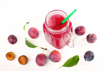plum juice in a glass with fresh plum fruit isolated on white backgroundの写真素材