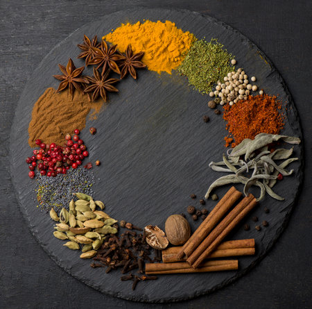Powder spices on spoons in black wooden table backgroundの写真素材