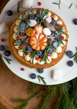 Christmas or New Year decorated cake with cream cheese frosting and cranberries