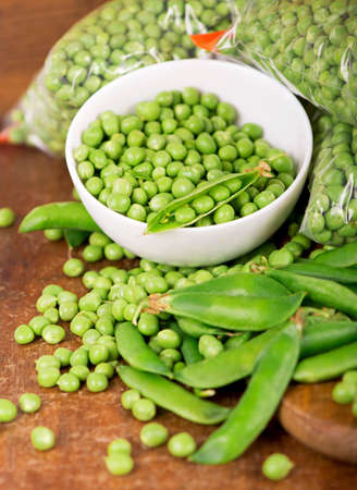 fresh green pea in bowl on wooden background.の写真素材
