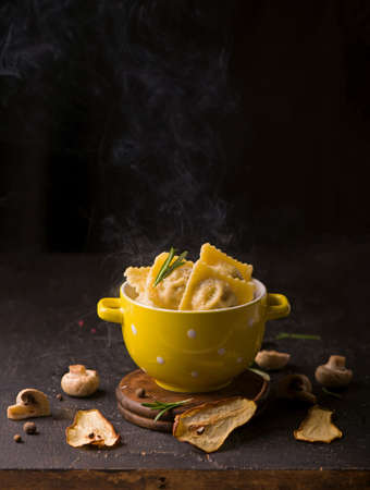 Fast food. Ravioli with spinach and ricotta cheese next to a laptopの写真素材