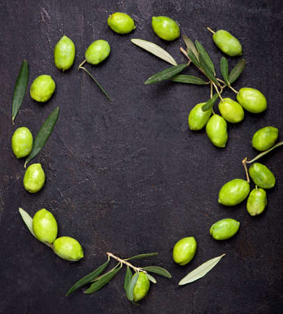 Olive oil and olive branch on the black backgroundの写真素材