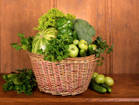 Useful green vegetables on a wooden background