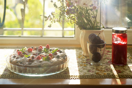 berry tart with fresh strawberries, raspberries, currants, mint and cream close up on the tableの写真素材