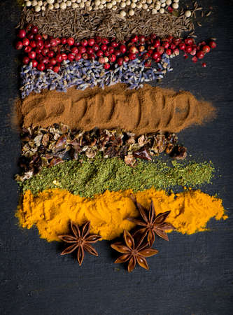 Powder spices on spoons in black wooden table background.の写真素材