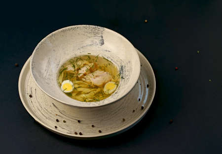 Chicken noodle soup - brothon a black background