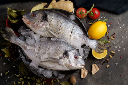 Raw dorado fish with spices cooking on cutting board.