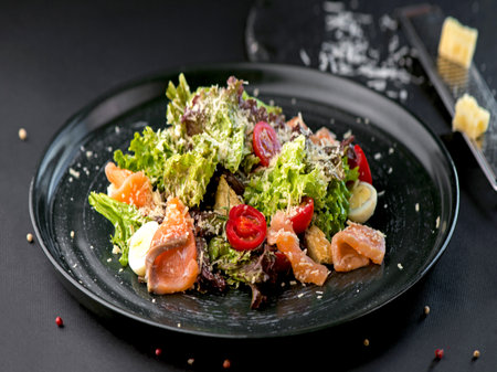 Vegetable salad with salmon and fresh herbs on a dark background. Side view, close-up.の写真素材