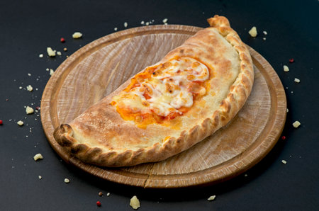 Georgian traditional food khachapuri on the wooden dish on black background