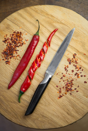 Red chili pepper cut into pieces on a black background. Hot spice, red chiliの写真素材
