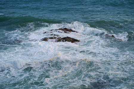 Waves crashing on seashore rocks,Top view sea surface waves background