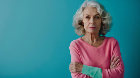 A mature woman with a graceful presence stands against a bold blue backdrop, exuding confidence and sophistication. A.I.の素材