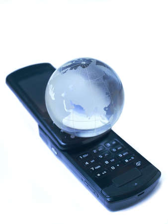 Mobile phone and  glass globe  isolatedの写真素材