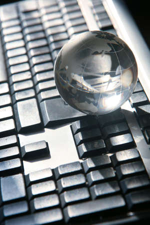  glass globe on the black keyboardの写真素材
