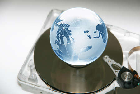 The glass globe on an axis of a computer hard diskの写真素材