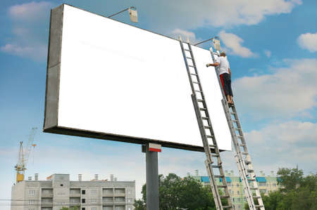 Rectangular white billboard and the worker changing the informationの写真素材