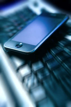 Mobile phone with big display on the computer keyboardの写真素材