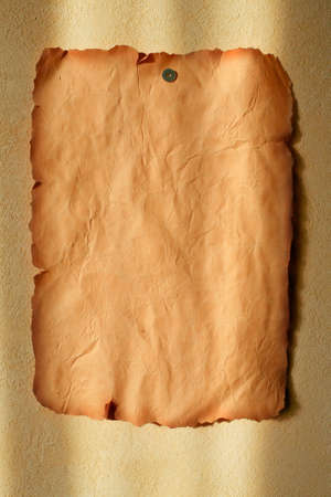 Old paper on the plastered wall with patches of light の写真素材