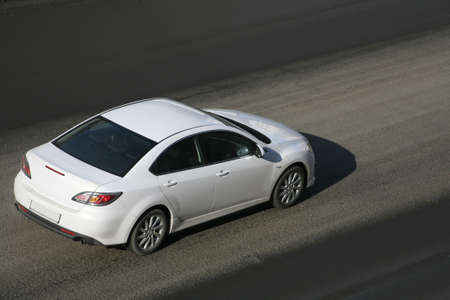 modern white car driving on city streetの写真素材