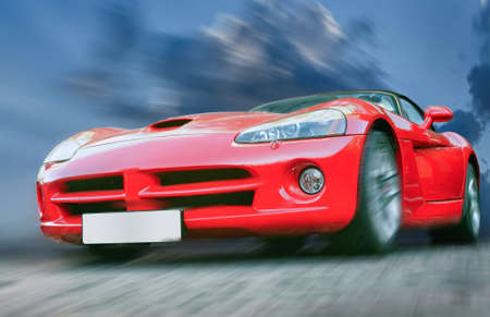 red sports powerful car on stone blocks against  skyの写真素材