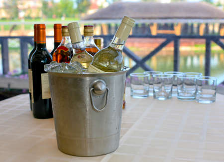 Bottles with wine cognac of brandy  bucket with ice on  tableの写真素材