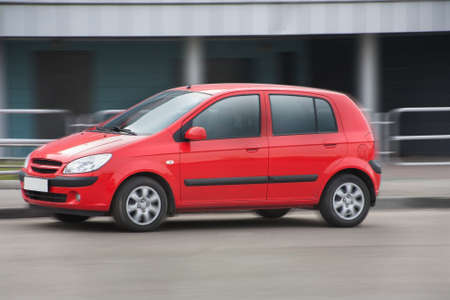 red car quickly goes on city streetの写真素材