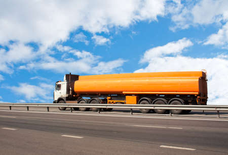 big gas-tank truck goes on highway against the skyの写真素材