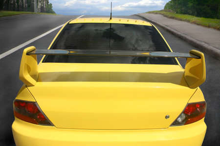 Yellow sports car on city roadの写真素材