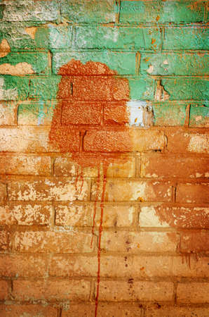 Old brick wall in paint stainsの写真素材