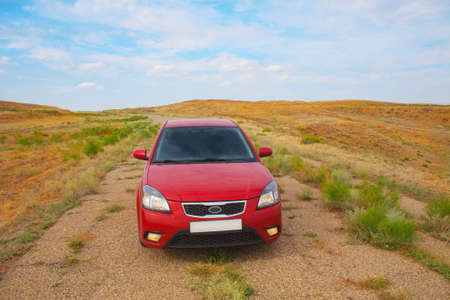 red car goes on the old roadの写真素材