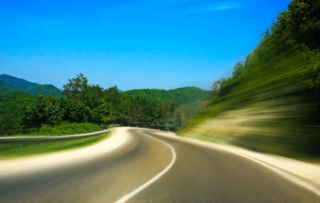 Twisting road to mountains blur movementの写真素材