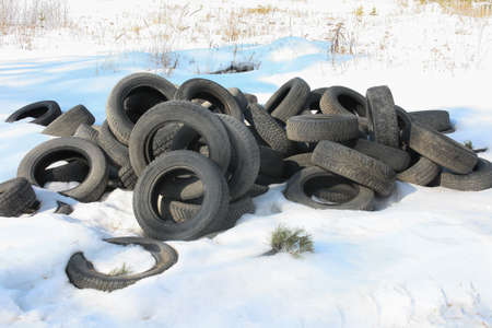 rubber tires dumped on snow in the fieldの写真素材