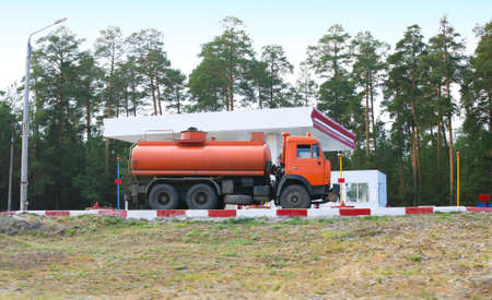 orange fuel truck at gas stationの写真素材