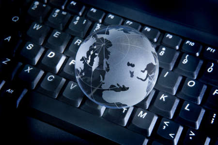glass globe on the computer keyboardの写真素材