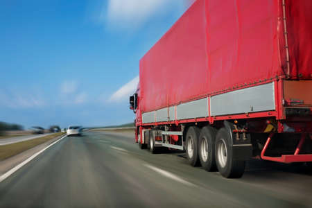 trailer with red awning moves at high speed on the highwayの写真素材
