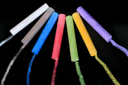 color pieces of chalk on black blackboardの写真素材