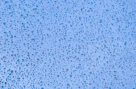 water drops on car windshield reflecting the skyの写真素材