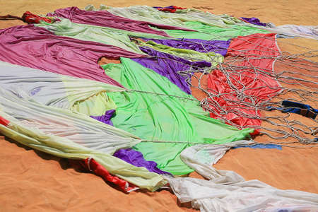 big color parachute spread out on sand