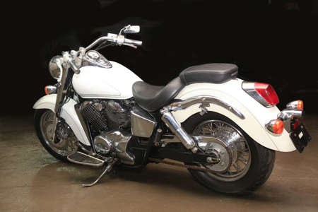 white powerful motorcycle against dark background