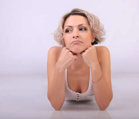 woman thoughtful sad lies leaning on elbowsの写真素材