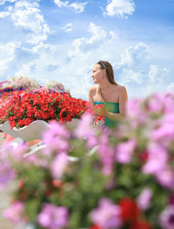 beautiful girl in flowers against the skyの写真素材