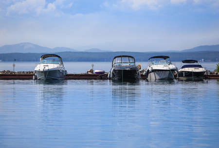 beautiful landscape with the lake and boats at pierの写真素材