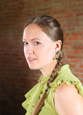 beautiful girl portrait against brick wallの写真素材