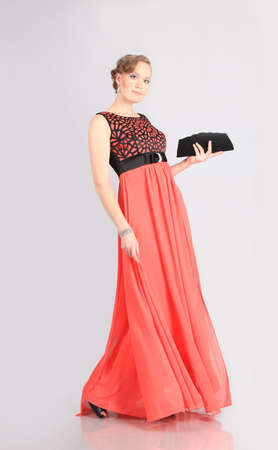 beautiful girl in red dress poses in studioの写真素材