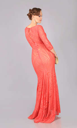 beautiful girl in red dress poses in studioの写真素材