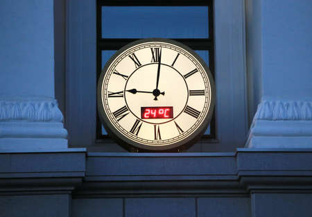 round city wall clock on the building in the evening