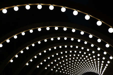 wooden arches with spherical shining lamps against dark backgroundの写真素材