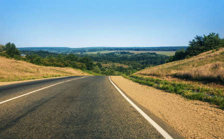 road going to distance against hilly landscapeの写真素材