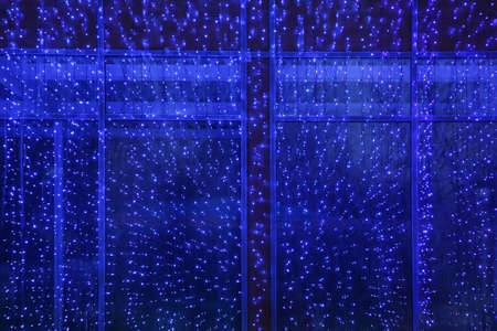 window frame illuminated by garlands at nightの写真素材