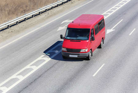 red minibus goes on the country highwayの写真素材
